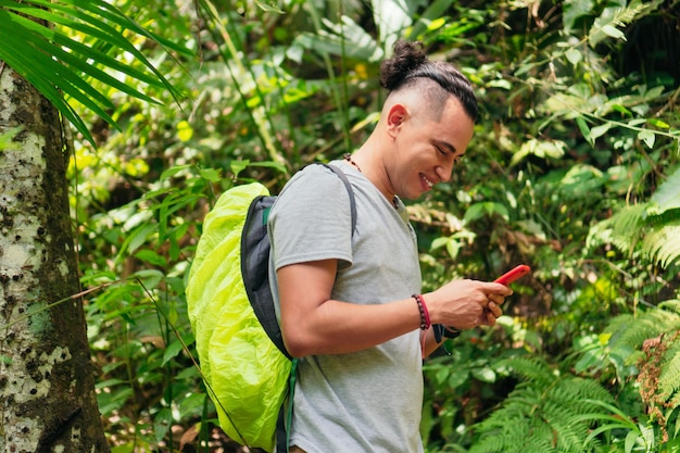 Man Using Phone In Tropical Forest