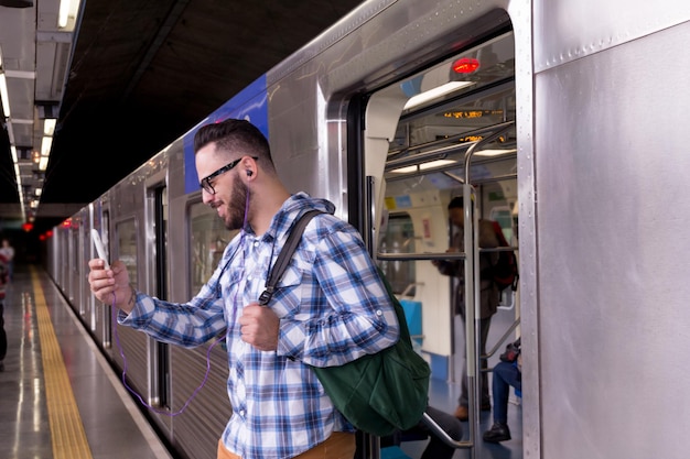 Photo man using phone while disembarking from train