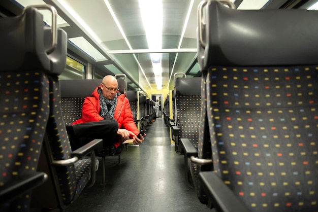 Photo man using phone while sitting in train