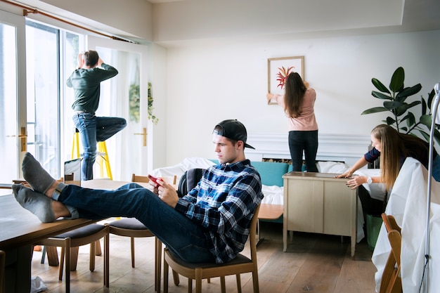 Photo a man using a smartphone as others are working