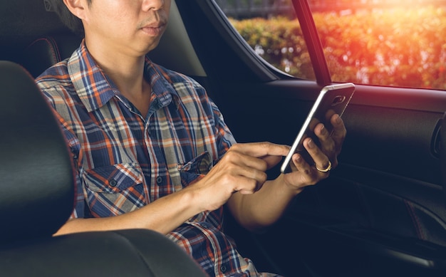 man using smartphone in car