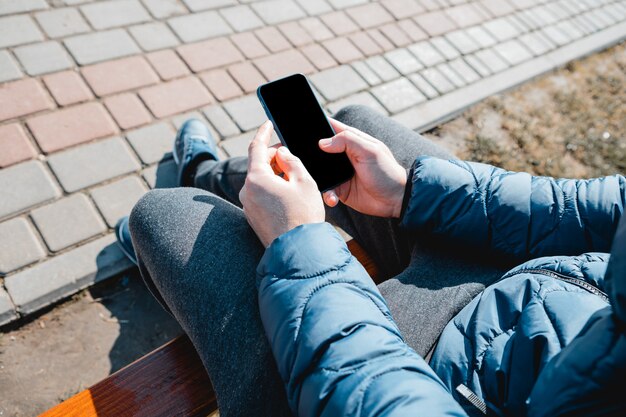 Uomo che usando uno smartphone in città