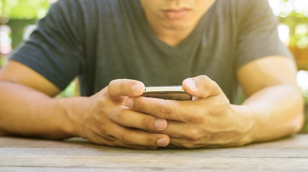 Foto uomo che utilizza uno smartphone in un giardino.