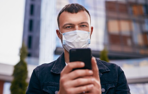 Man using smartphone during pandemic on street