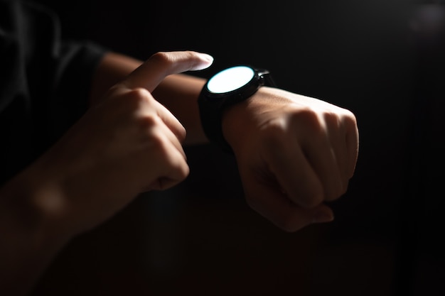 Photo a man using a smartwatch at night.
