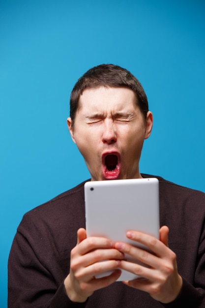 파란색 배경 소셜 미디어 개념에서 태블릿 컴퓨터를 사용하는 남자