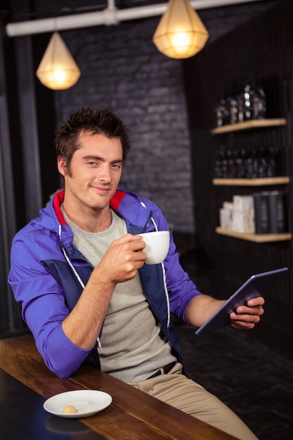 Man using a tablet and drinking coffee