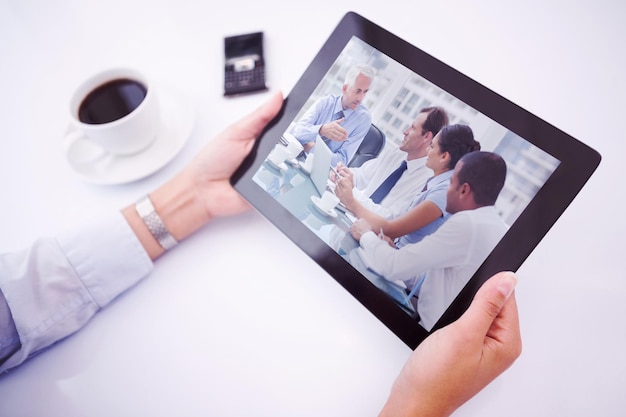Man using tablet pc against group of business people brainstorming together