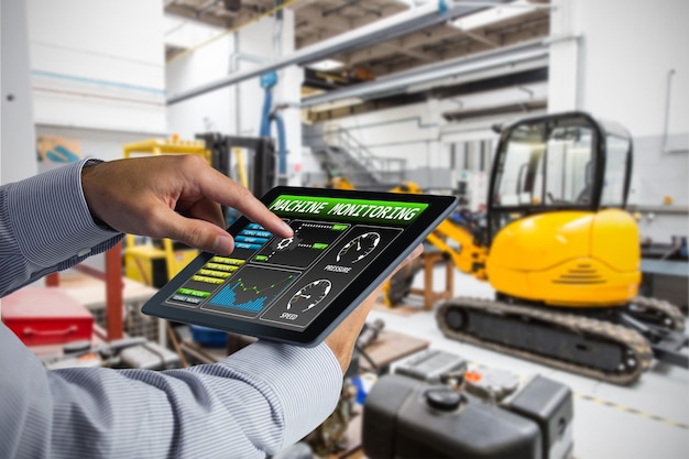 Foto uomo che utilizza tablet pc contro apparecchiature industriali in fabbrica