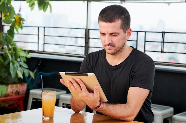 Man using tablet pc in cafe