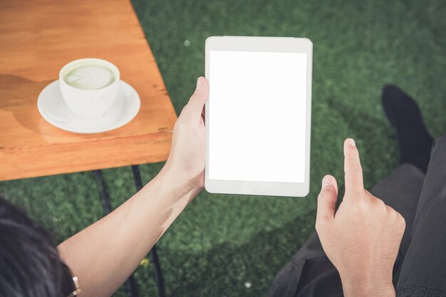 Man using tablet for shopping and while relaxing on sofa in modern office.