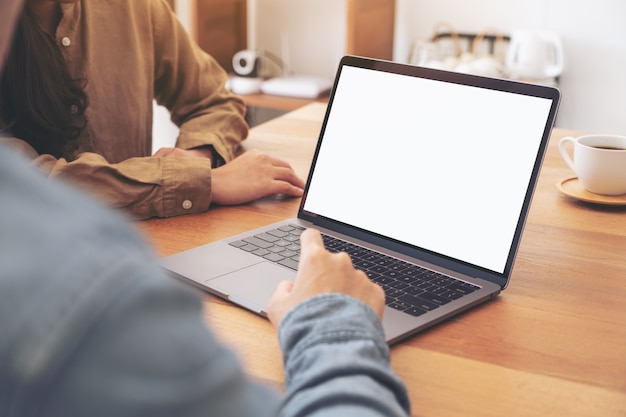 A man using and touching on mockup laptop computer touchpad with colleagues in meeting