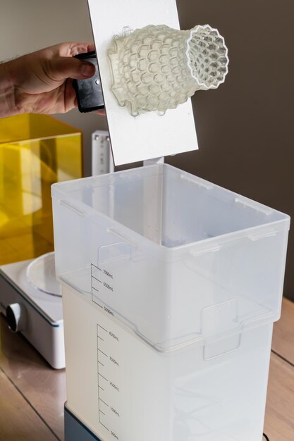 Man using a wash machine to clean a transparent 3d resin object