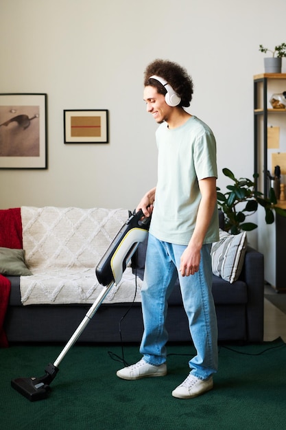 Man vacuuming carpet in the living room