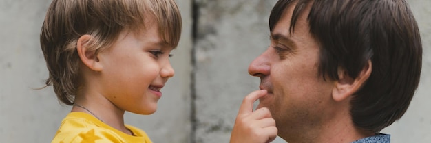 Man vader met quality time met hun kind zoon jongen zes jaar oud op armen gelukkige vader spelen samen met kind het echte leven authentieke dag van vandaag vaderschap momenten vaderlijke liefde zorg banner