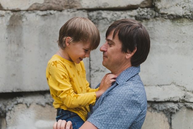 Man vader met quality time met hun kind zoon jongen zes jaar oud op armen gelukkige vader spelen samen met kind het echte leven authentieke dag van vandaag vaderschap momenten vaderlijke liefde zorg en genegenheid