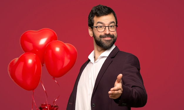 Man in valentine day shaking hands for closing a good deal over red background