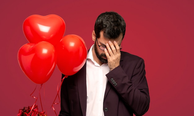 Man in valentine day with tired and sick expression over red background