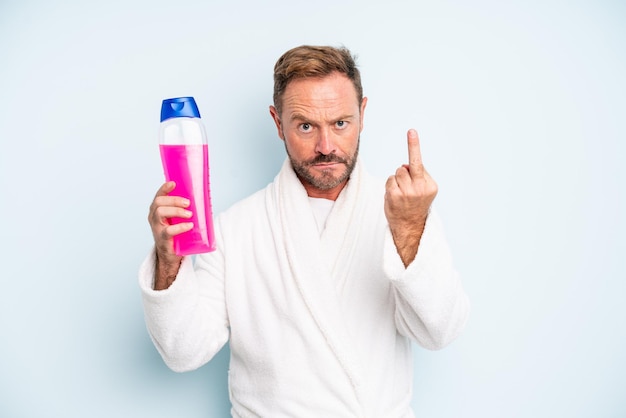 Man van middelbare leeftijd die zich boos, geïrriteerd, opstandig en agressief voelt. shampoo fles