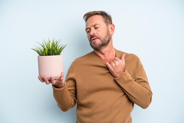 Man van middelbare leeftijd die zich gestrest, angstig, moe en gefrustreerd voelt. plant pot concept