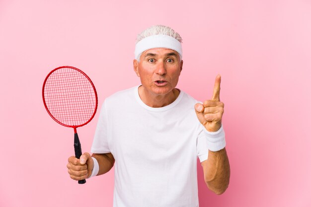 Man van middelbare leeftijd spelen badminton met een idee