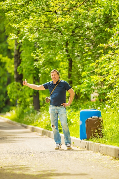 man vangt een passerende auto op een zonnige dag