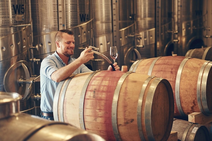 Foto man vat en wijnmaker met glas als manager voor het proefproces en de productie leverancier wijnmakerij en blij of glimlachen bij het product voor de productie van alcohol ambacht en drank in de fabriek in start-up
