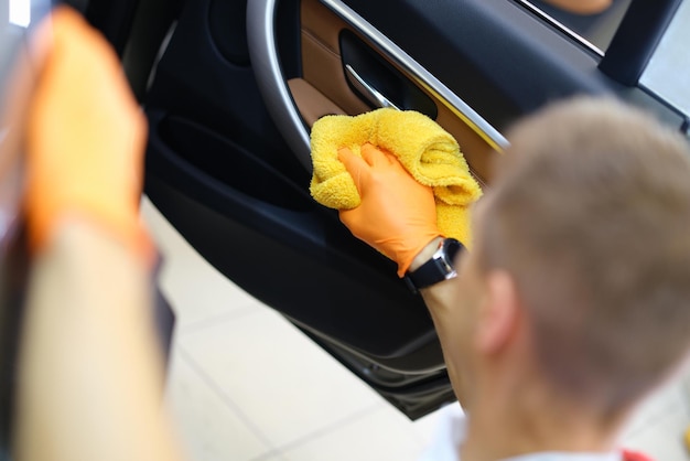 Man veegt het interieur van de auto af met een handdoek