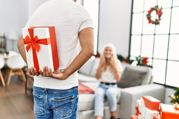 Man verrassende vrouw met kerstcadeau thuis