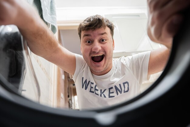 Man view from washing machine inside Male does laundry daily routine Funny comedian face