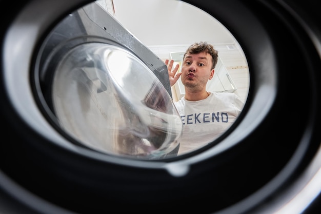 Man view from washing machine inside Male does laundry daily routine Kiss you