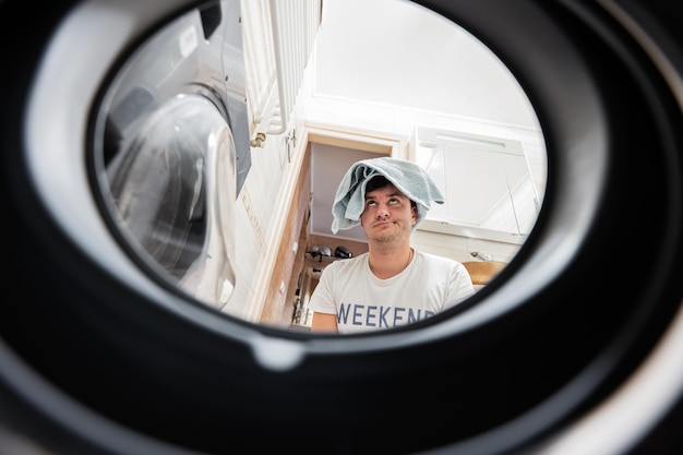 Man view from washing machine inside Male does laundry daily routine