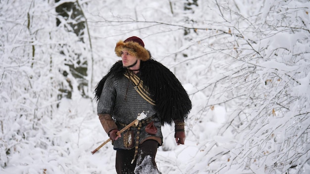 Man Viking die in het winterbos gaat. Hij kleedde zich in middeleeuwse kleding.