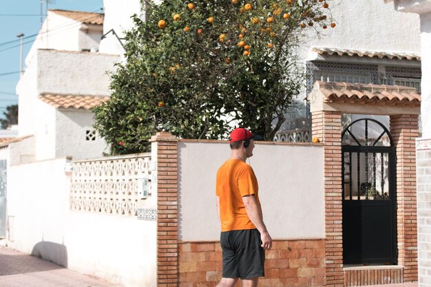 A man at a villa with an orange tree