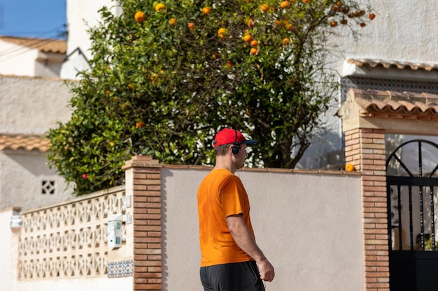 A man at a villa with an orange tree