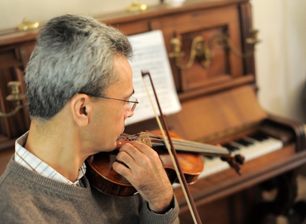 man and violin with score