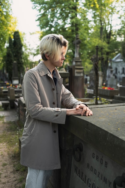 Foto uomo che visita una tomba al cimitero