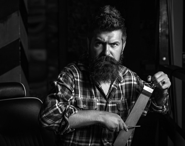 Man visiting hairstylist in barber shop trims barber shaving a bearded man in a barber shop he is do