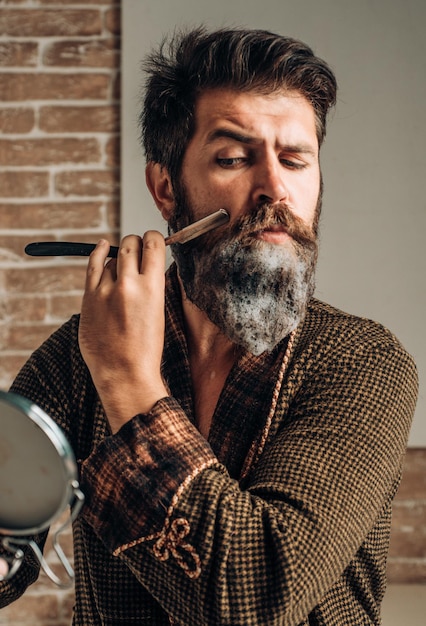 man visiting hairstylist in barber shop trims he is doing styling with the shaver shaving man and