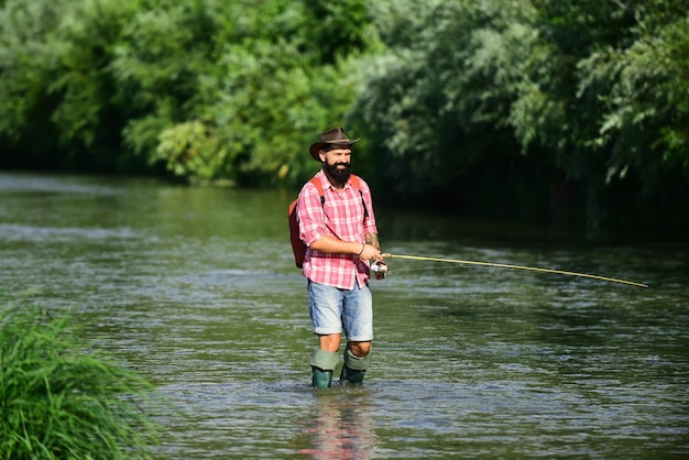 Man vissen en ontspannen terwijl hij geniet van hobby een visser met hengel op de rivier visser an