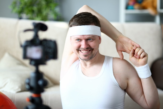 Man Vlogger doet oefening voor handenportret. Gelukkige sportman opname fitness training op digitale camera voor Sport Vlog.