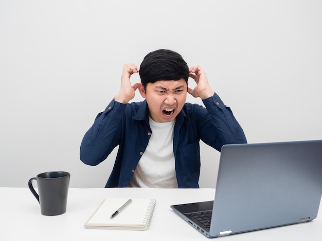 Man voelt zich gespannen met werken terwijl hij naar een laptop op het bureau kijkt