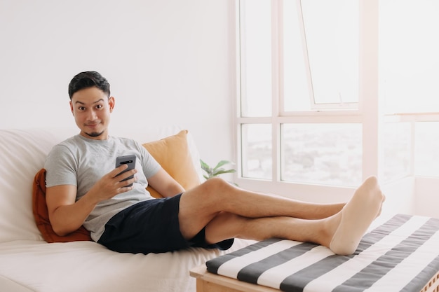 Man voelt zich ontspannen en opgelucht met handelszaken op mobiel in zijn huis