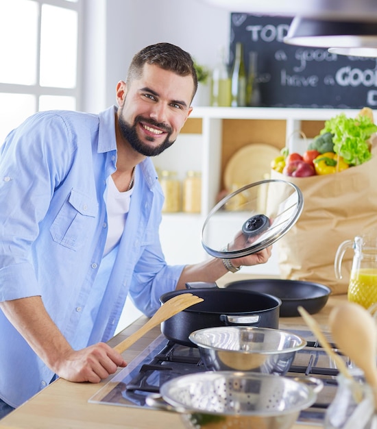 Man volgt recept op digitale tablet en kookt lekker en gezond eten in de keuken thuis