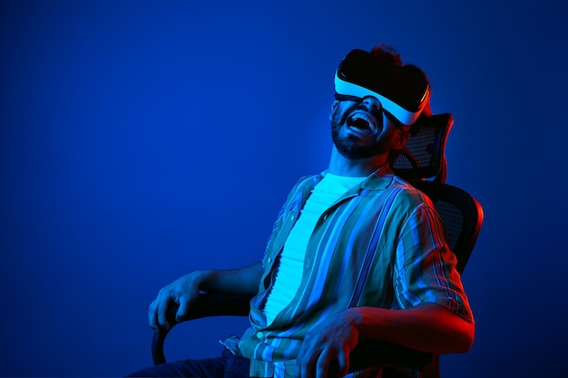 Man in vr headset looking away with scary expression while sitting on chair