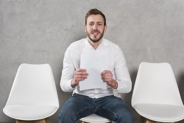 Photo man waiting for his job interview and holding resume