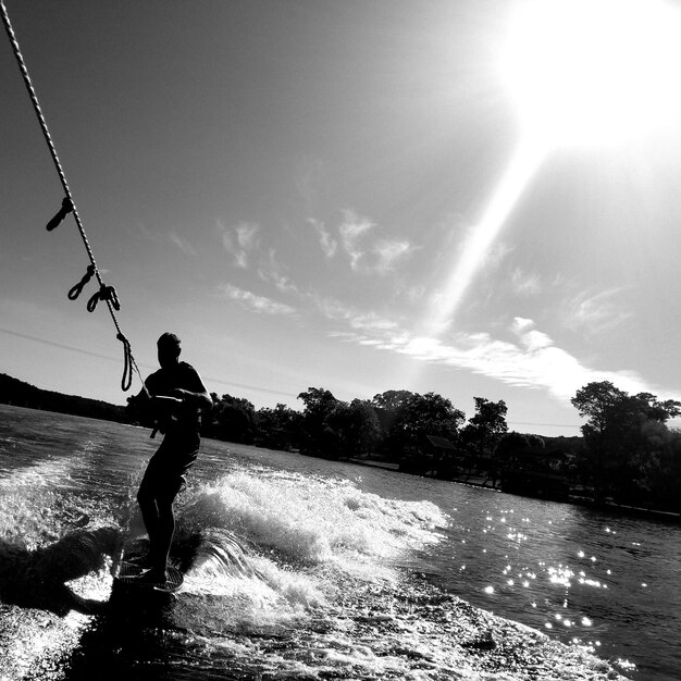 Photo man wakeboarding on river against sky