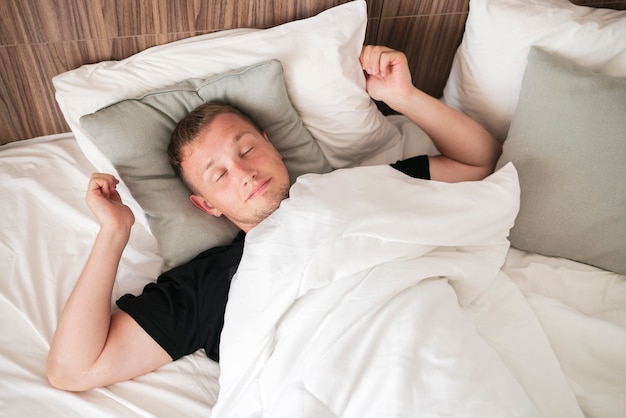 A man waking up in the morning, stretching the body and open eyes