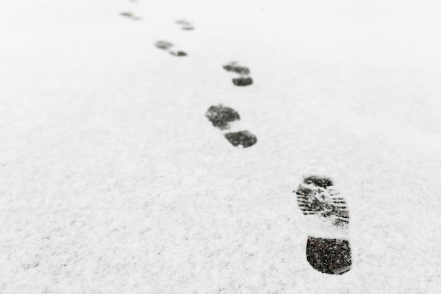 男が歩いた、彼は雪の中に足跡を残しました