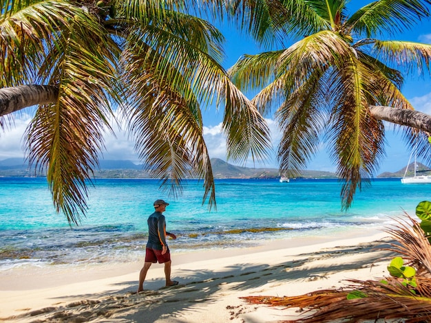 Photo man walking along a beach in grenada